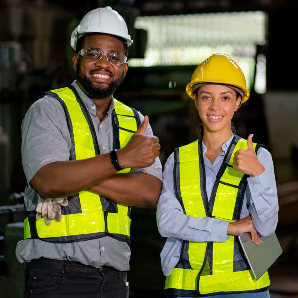 Factory workers man and woman show thumbs up